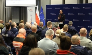 Męczyna przemawia do zgromadzonych na sali gości konferencji.